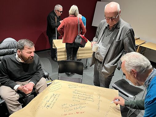 World Café Gruppen zu "Freie Gehwege", im Hintergrund der "Themenspeicher-Tisch.