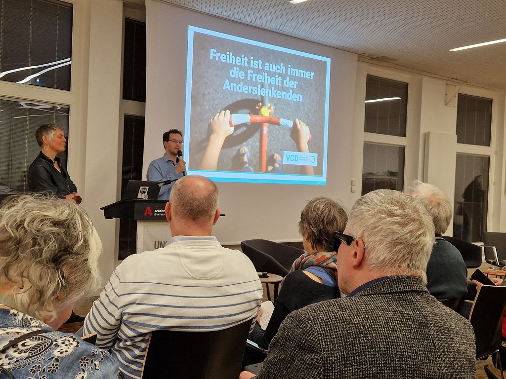 Präsentation Zu Fuss 1 - Eröffnungsbild "Freiheit ist die Freiheit der Anderslenkenden" (Blick auf den Lenker eines Laufrades und auf Asphalt